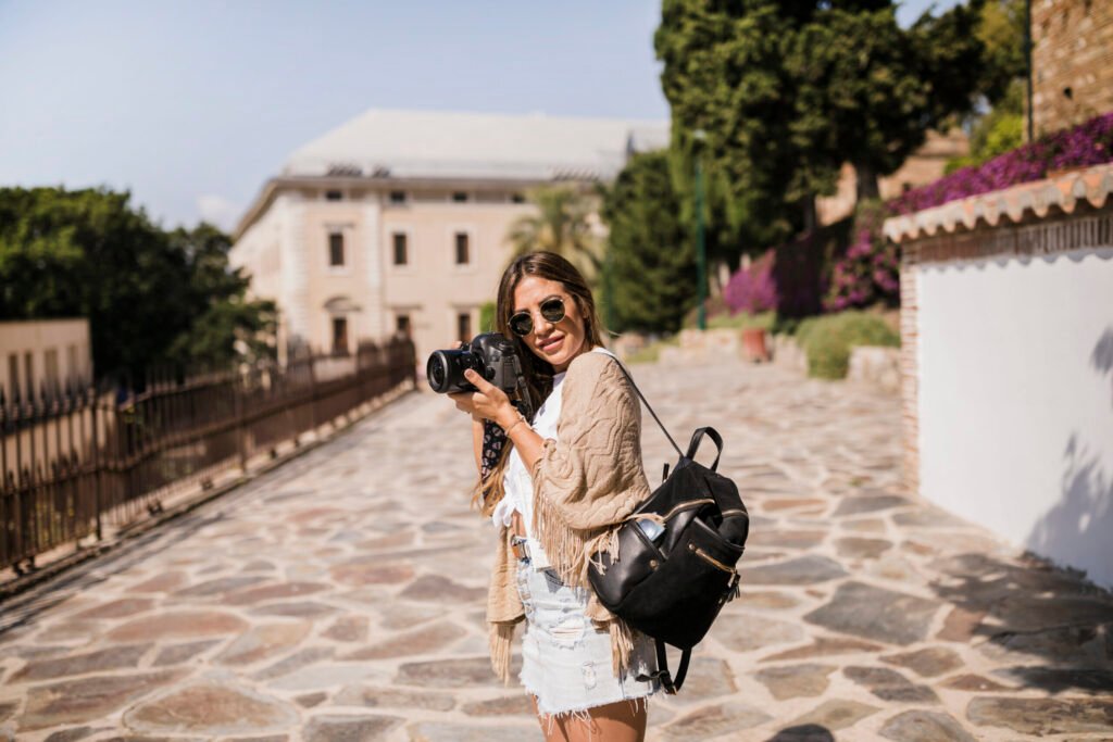 female photographer with her backpack standing street scaled